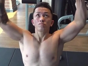 A handsome Asian man getting fit in the gym before a nipple play session.